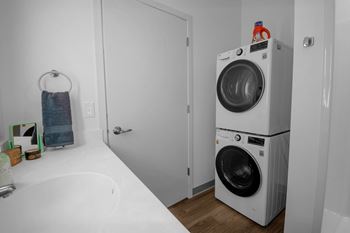 A white washing machine is in a small laundry room.